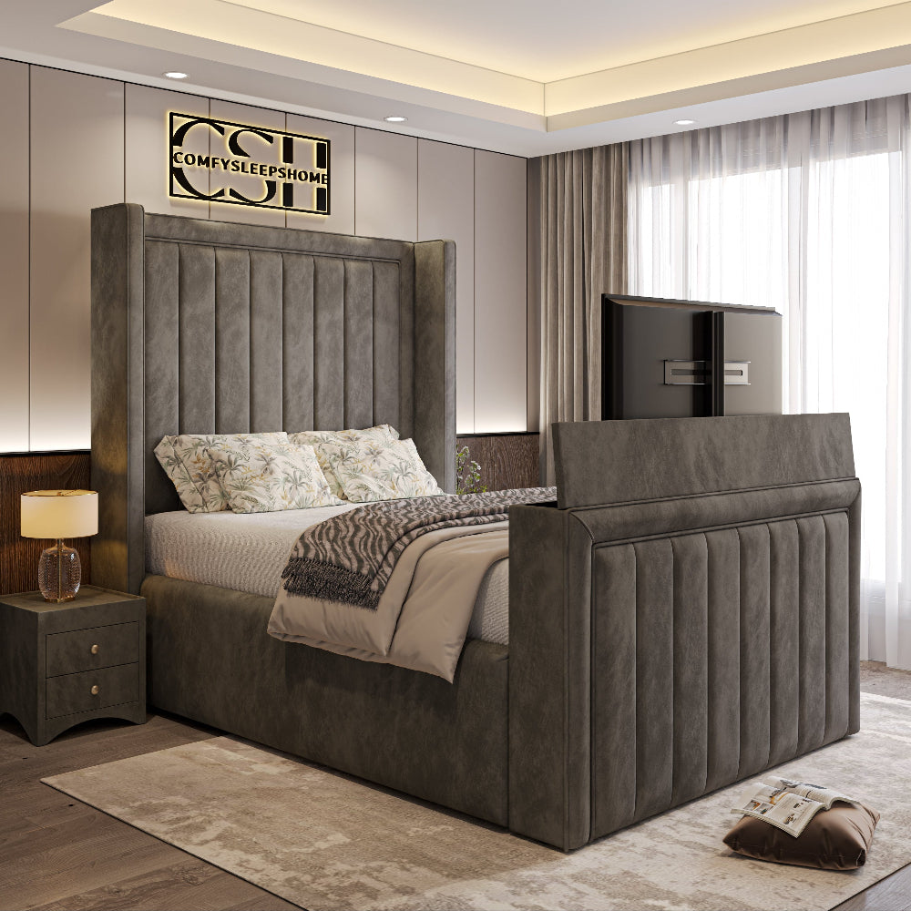A modern grey 2025 The Astoria TV Bed with a tall, panelled headboard and a pop-up TV footboard, enhancing a stylish bedroom.
