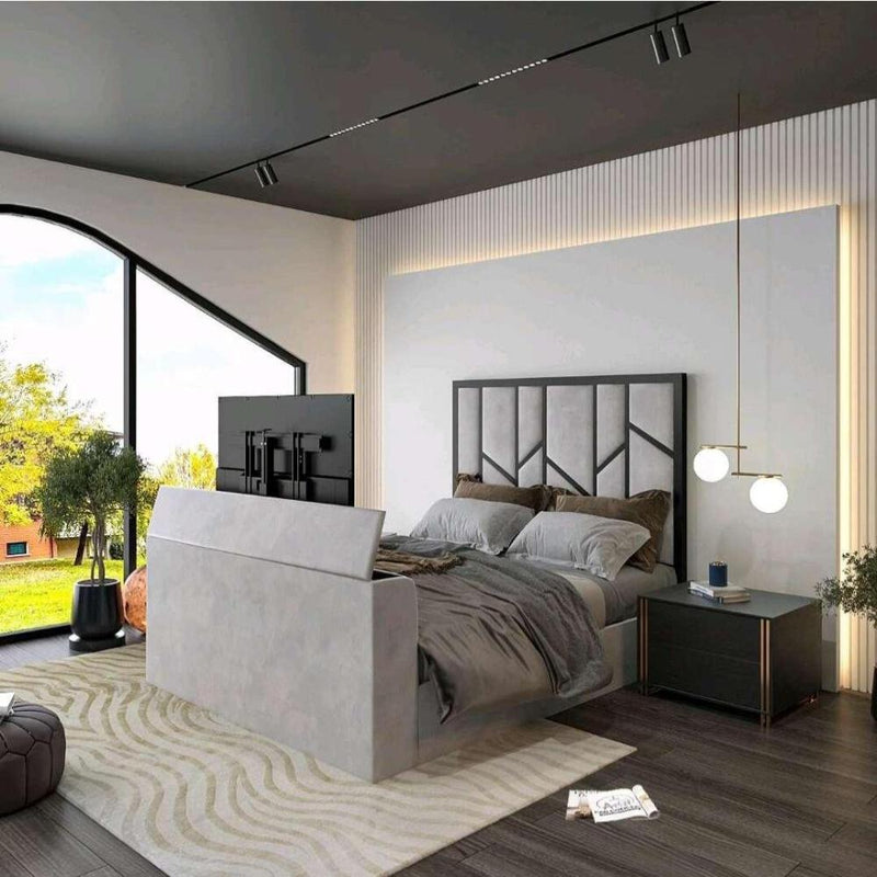 Modern bedroom with a gray upholstered Zig Zag Tv bed, flat-screen TV, black nightstand, and large window view of greenery.