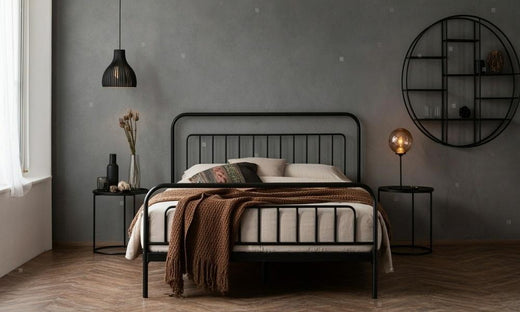 Bedroom with a black metal double bed frame, gray wall, and modern decor.