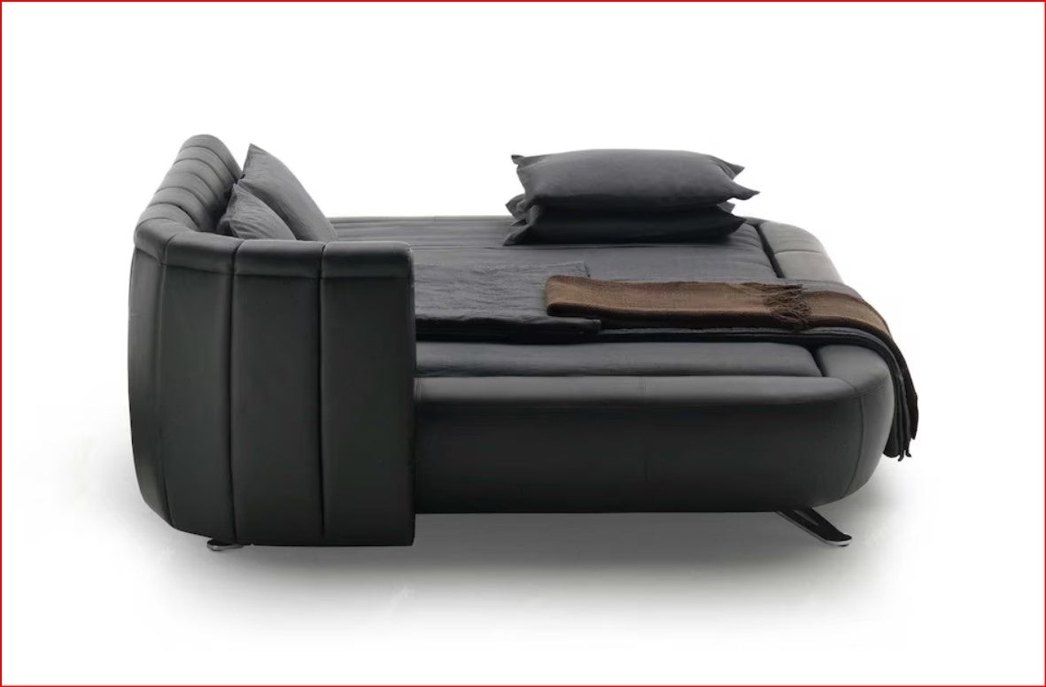 A modern black sofa bed with leather-like upholstery, shown in a bed position.