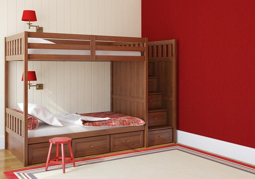 Bunk bed with slide, red bedding, and wall-mounted lamps in a red-accented room.