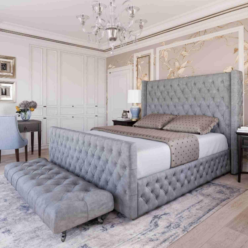 Luxurious and stylish bedroom with a king-size ottoman bed. The bed features a tufted headboard and a gray velvet upholstered frame, creating a sophisticated and elegant look. 