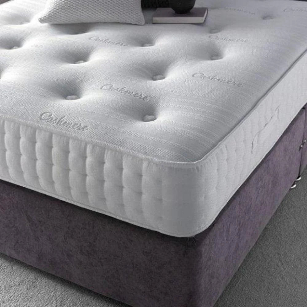 Close-up of a white orthopedic mattress with tufting and embossed text.