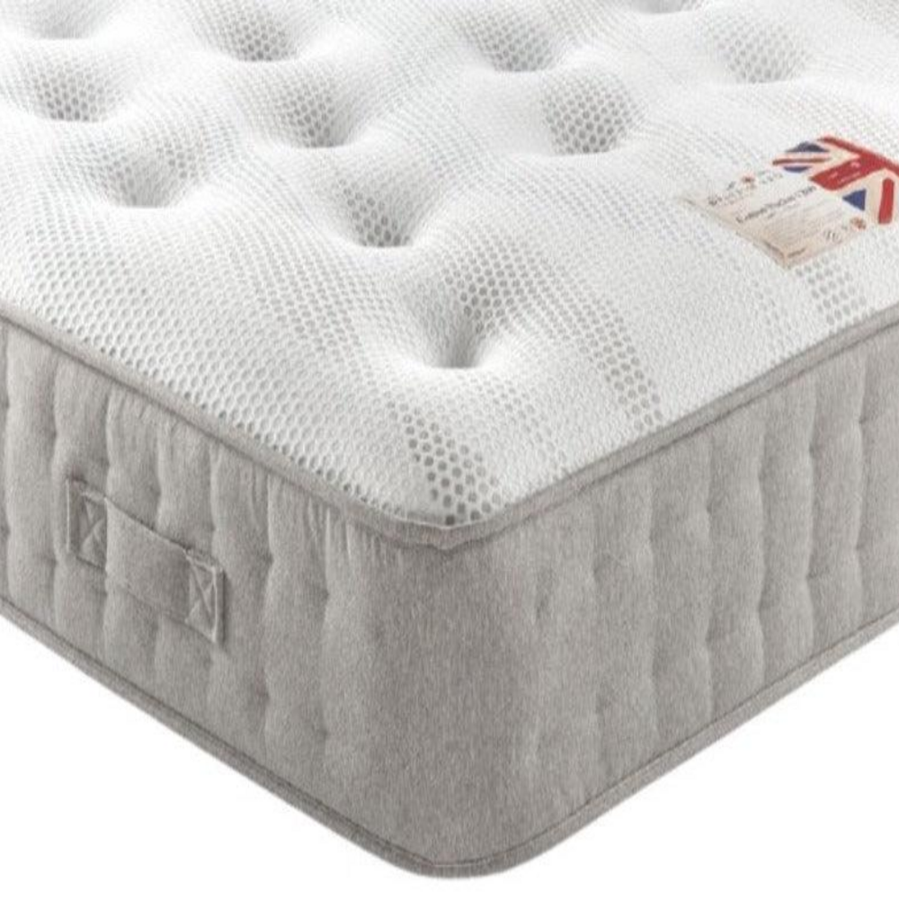 Close-up of a pocket sprung mattress with a textured white top and grey quilted sides.