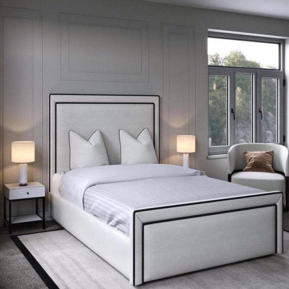 Modern bedroom with a white shorty bed, black-outlined headboard, and two nightstands.