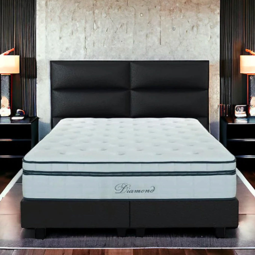 Modern bedroom with a large bed, padded headboard, Diamond quilted mattress, bedside tables, and lamps.