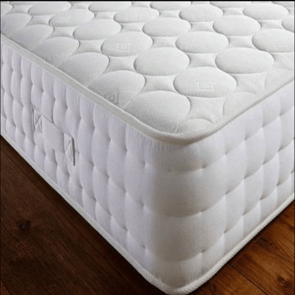 White quilted small single mattress on a wooden floor.