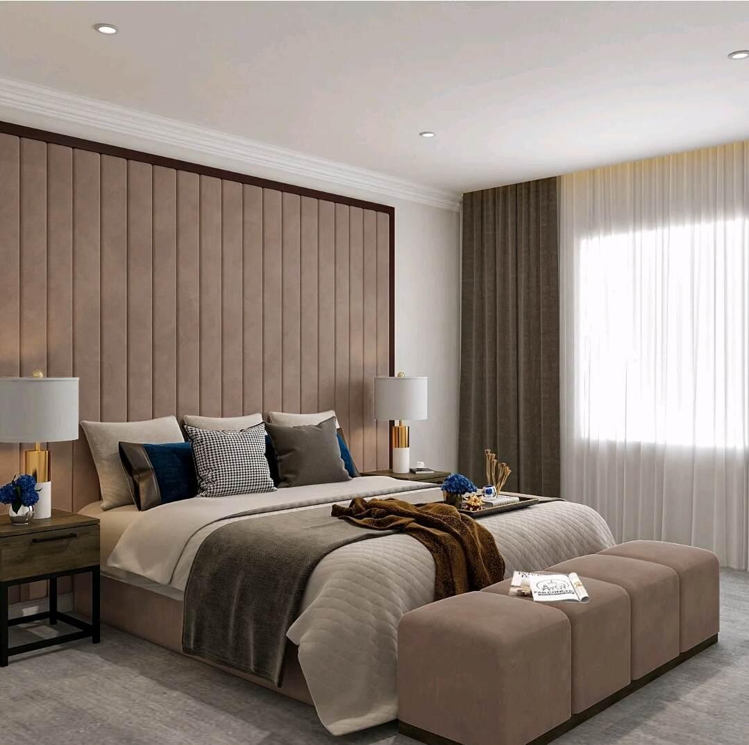 Modern bedroom with a large upholstered wall panel bed, decorative pillows, and bedside tables with lamps.