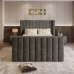A modern grey 2025 Lynza TV Bed with a tall, channel-tufted headboard and matching footboard, set in a stylish bedroom.