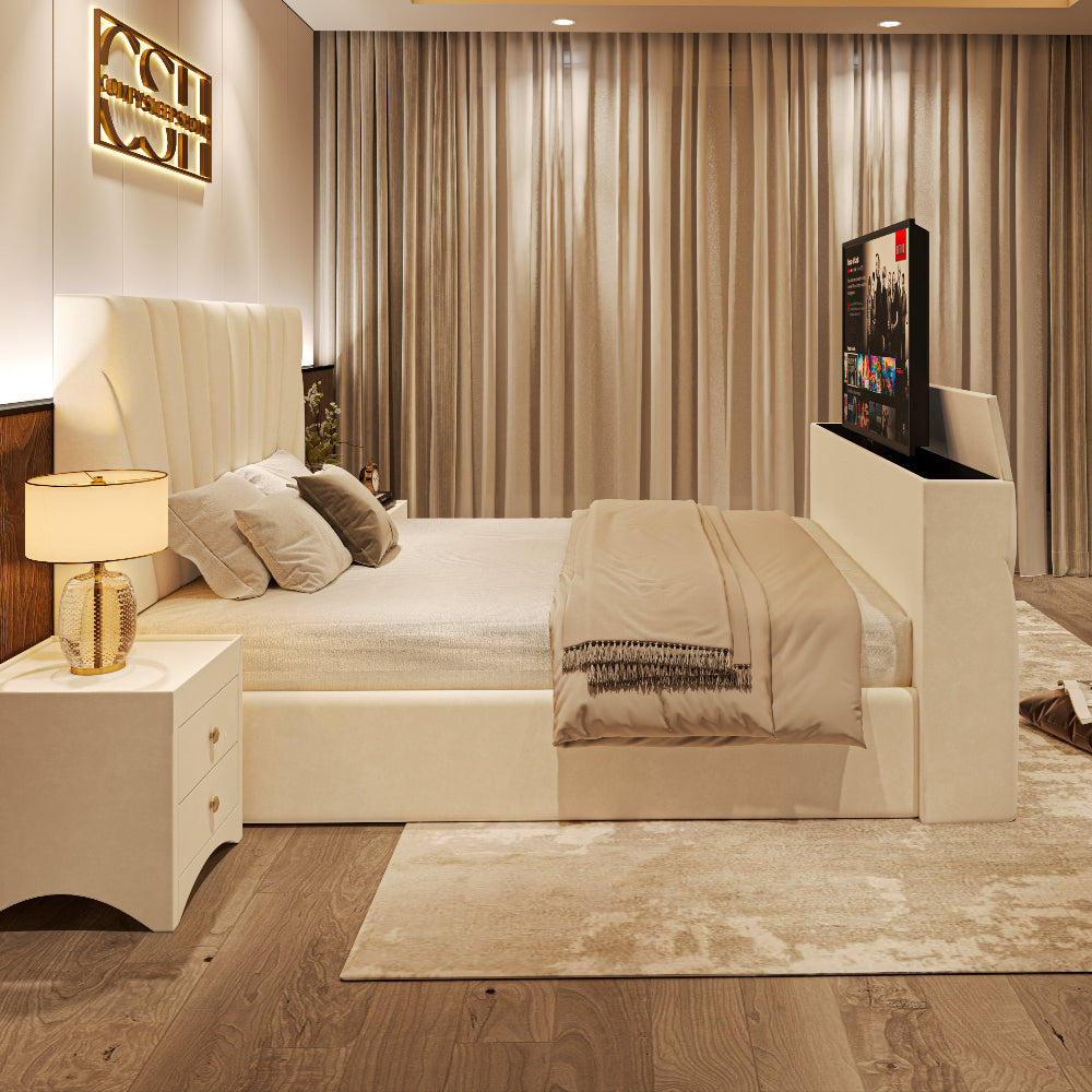 A contemporary white upholstered 2025 The Chelsea TV Bed with a channel-tufted headboard and integrated television in a bedroom.
