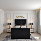 Modern bedroom with a black- windsor Tv bed and footboard, decorated with golden leaves above the headboard, a side table with a lamp, and gray curtains by a window seat.