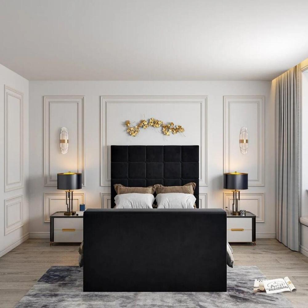 Modern bedroom with a black- windsor Tv bed and footboard, decorated with golden leaves above the headboard, a side table with a lamp, and gray curtains by a window seat.