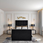 Modern bedroom with a black- windsor Tv bed and footboard, decorated with golden leaves above the headboard, a side table with a lamp, and gray curtains by a window seat.